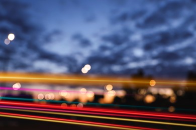 Blurred view of cityscape with light trails at evening, motion blur effect