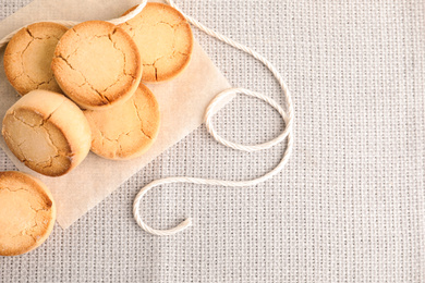 Photo of Sweet tasty homemade cookies on tablecloth, flat lay