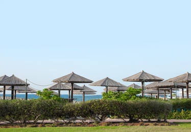 Photo of Beautiful landscape with beach umbrellas at tropical resort on sunny day