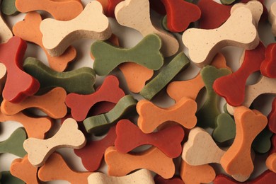 Photo of Many bone shaped vitamins for pets as background, top view