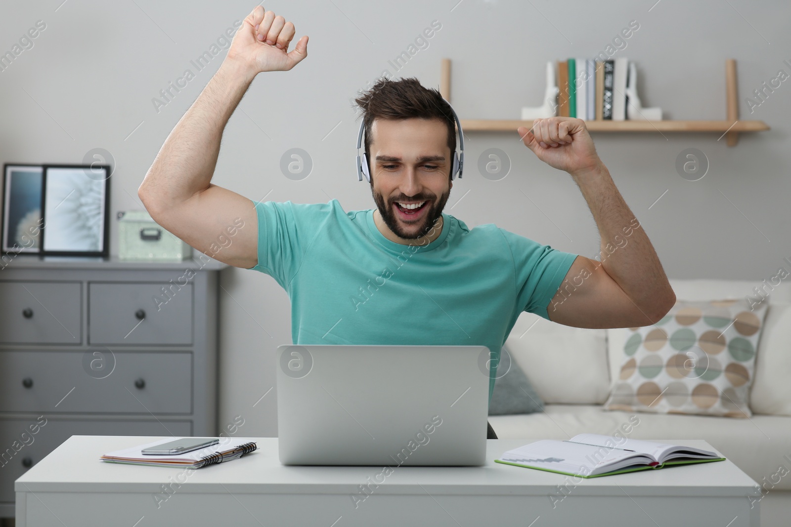 Photo of Online test. Happy man studying with laptop at home