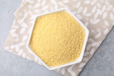 Photo of Raw couscous in bowl on table, top view