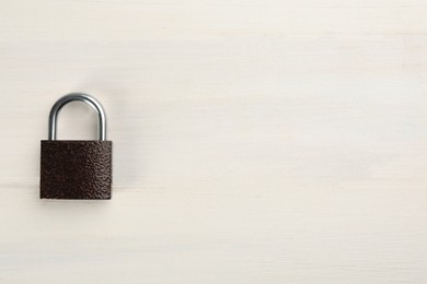 Modern padlock on white wooden table, top view. Space for text