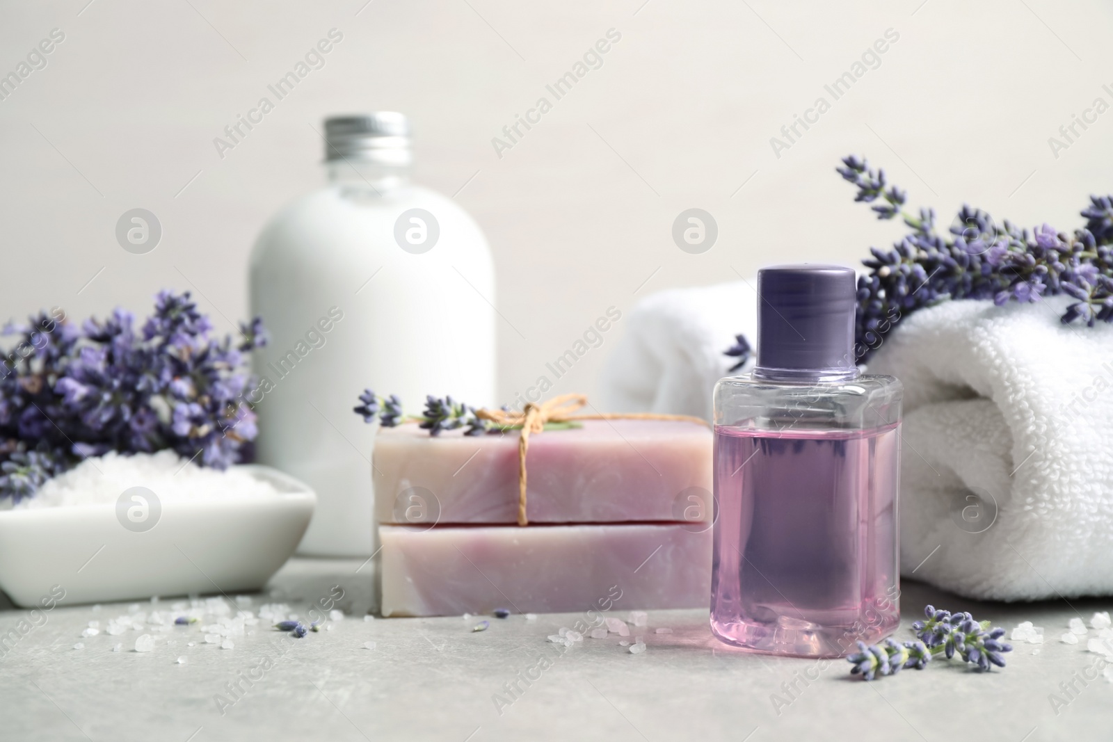 Photo of Cosmetic products and lavender flowers on light table