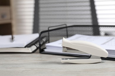 Photo of Stapler on wooden table indoors, space for text. Office stationery