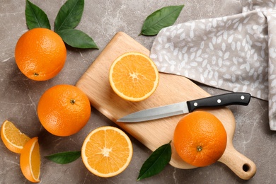 Delicious ripe oranges on grey marble table, flat lay