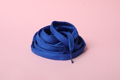 Photo of Blue shoe lace on light pink background