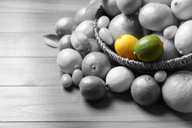 Different citrus fruits on wooden table. Black and white tone with selective color effect