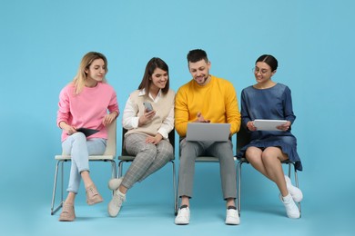 Photo of People waiting for job interview on light blue background