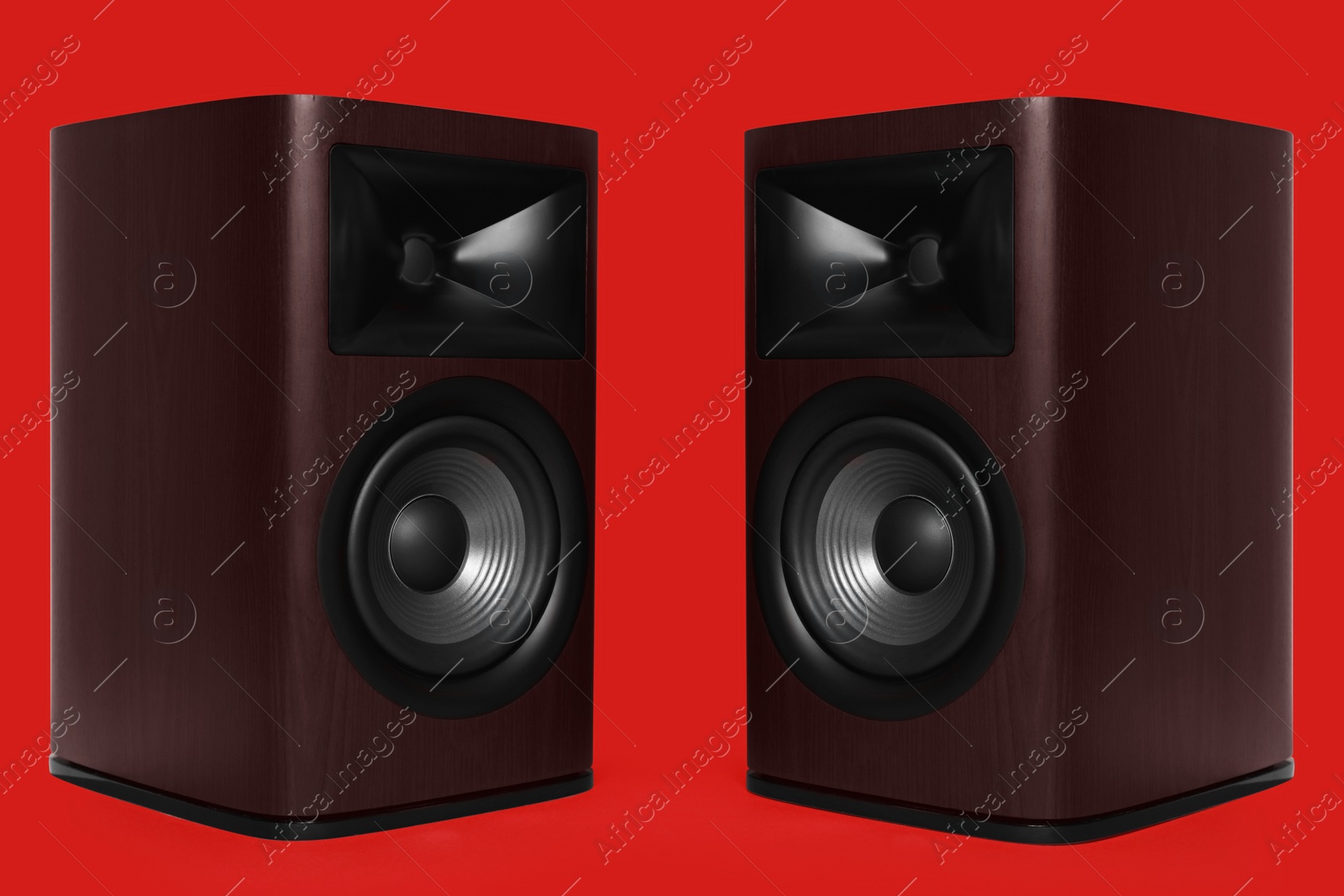 Photo of Modern wooden sound speakers on red background