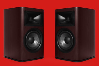 Photo of Modern wooden sound speakers on red background