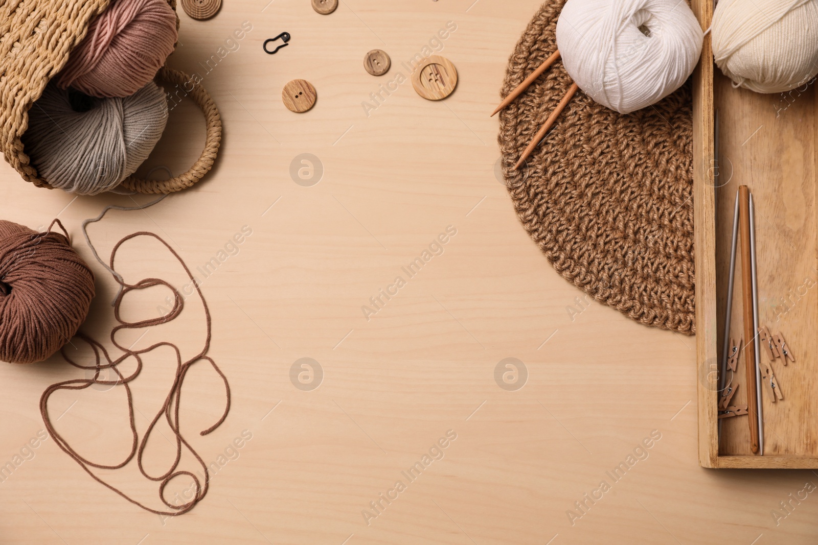 Photo of Flat lay composition with threads and crafting accessories on wooden table, space for text. Engaging hobby