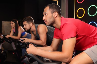 Photo of Group of people training on exercise bikes in fitness club