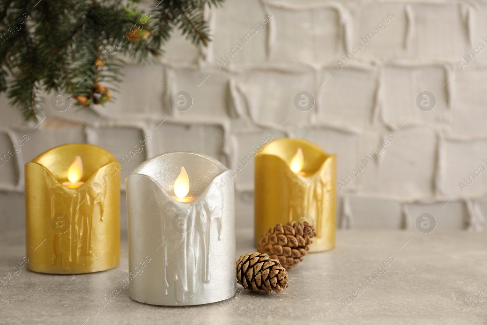 Photo of Decorative LED candles and conifer cones on light table