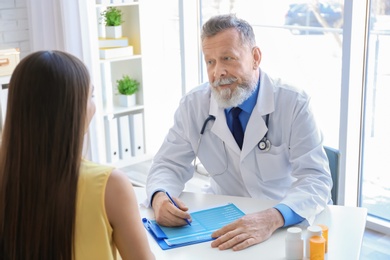 Photo of Mature doctor consulting patient in clinic