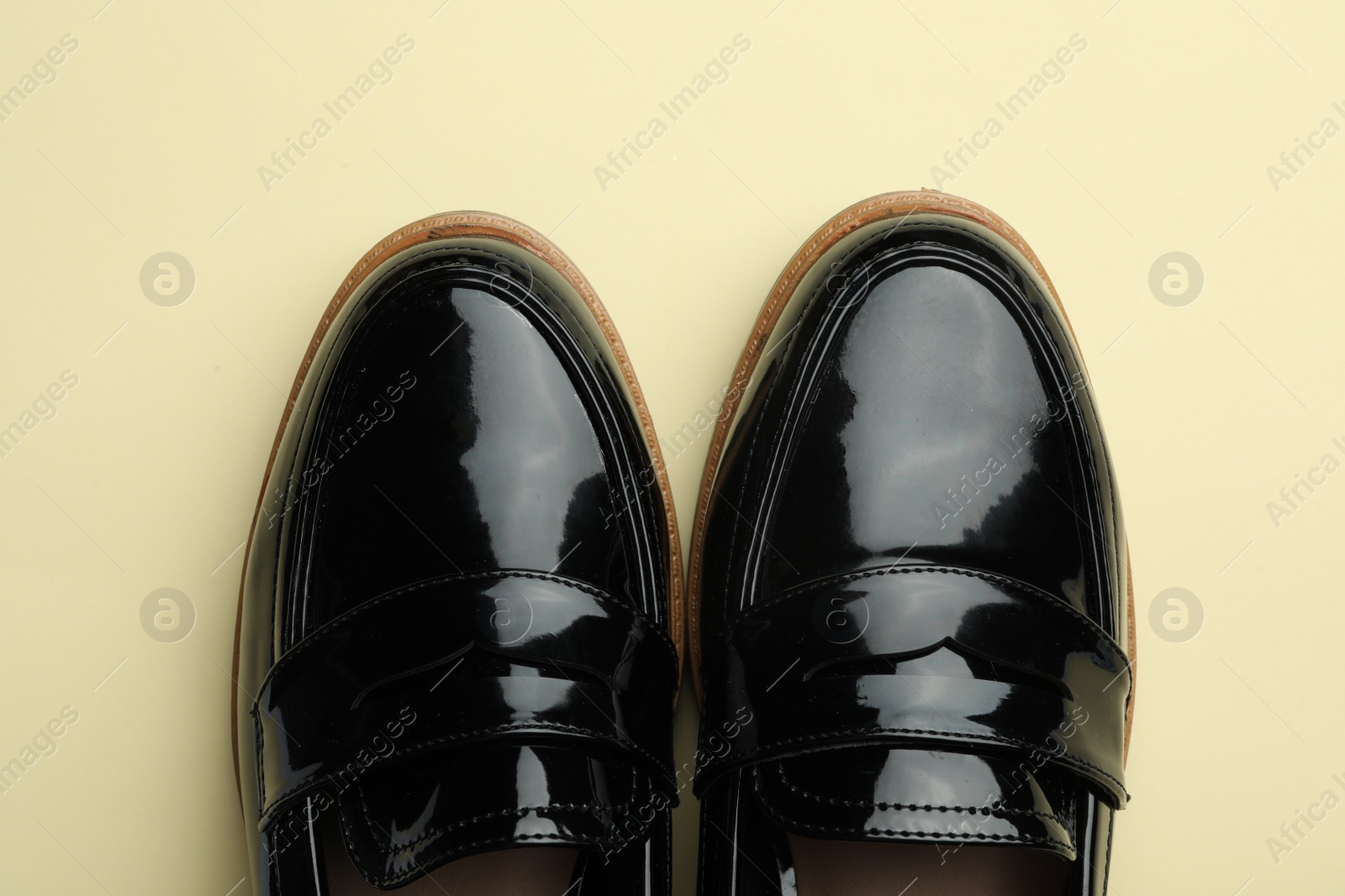 Photo of Pair of stylish female shoes on yellow background, top view