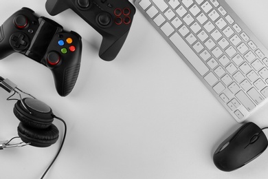 Photo of Gamepads, mouse, headphones and keyboard on table