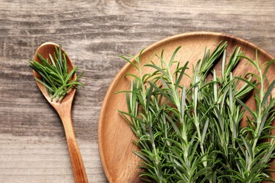 Fresh rosemary sprigs on wooden table, flat lay