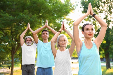 Photo of Group of people practicing morning yoga in park