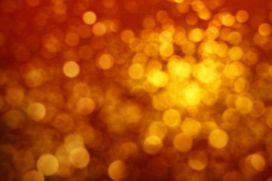 Photo of Blurred view of golden lights on red background. Bokeh effect