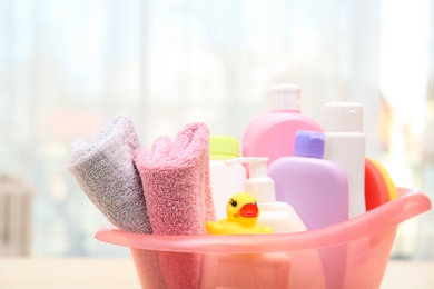 Photo of Baby cosmetic products, toy and towels indoors, closeup