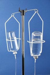 Photo of Infusion set on blue background. Intravenous therapy