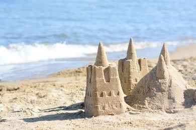 Photo of Beach with sand castle near sea on sunny day. Space for text