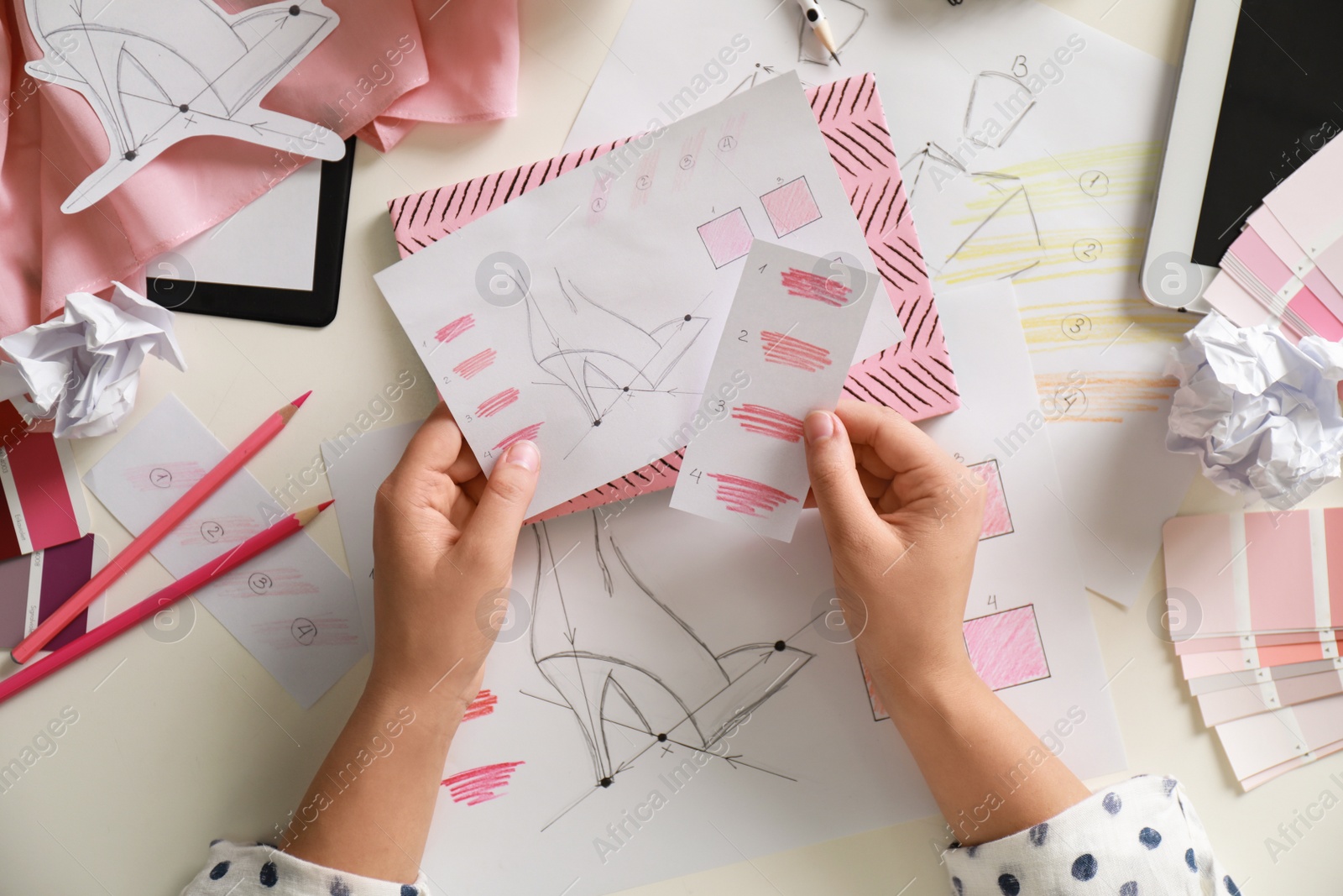 Photo of Female fashion designer working at white table, top view