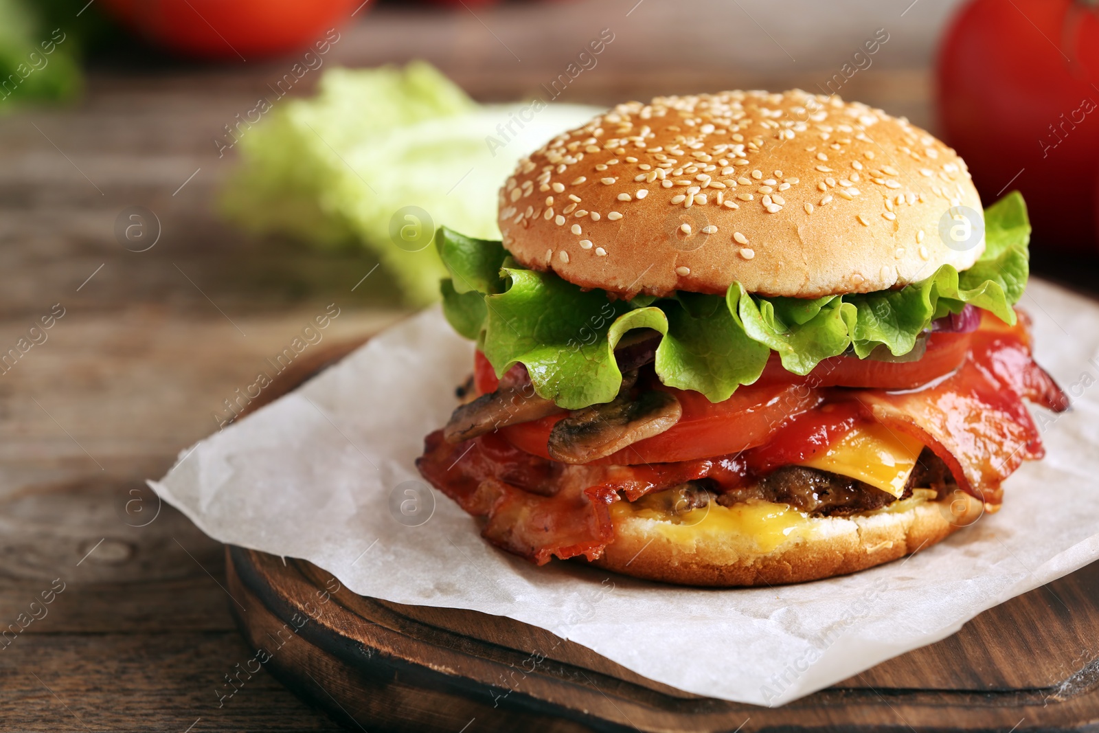 Photo of Tasty burger with bacon on wooden table. Space for text