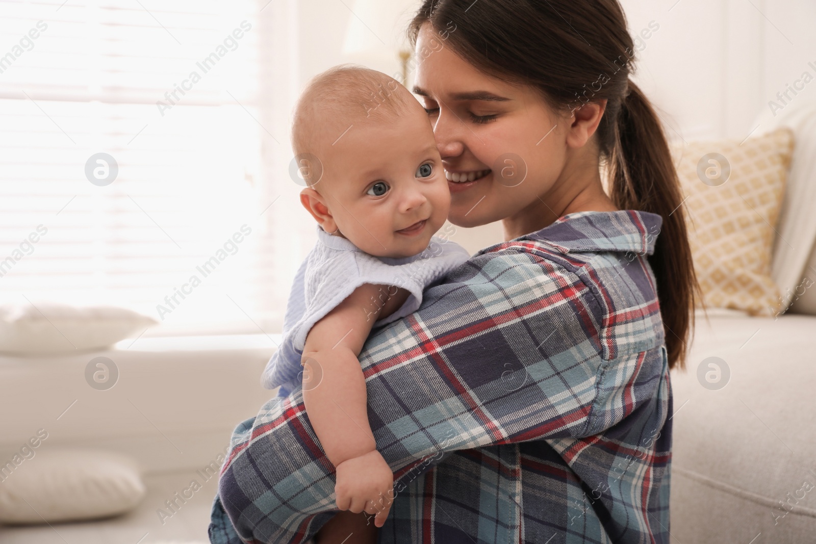 Photo of Happy young mother with her cute baby at home