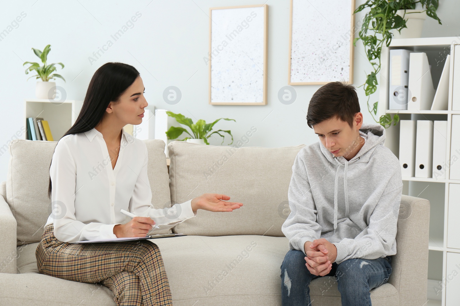 Photo of Young psychologist working with teenage boy in office