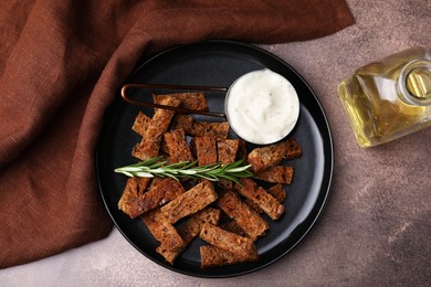 Crispy rusks with rosemary and sauce on grey table, flat lay