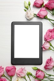 Photo of E-book reader with flowers on white wooden table, flat lay. Space for text