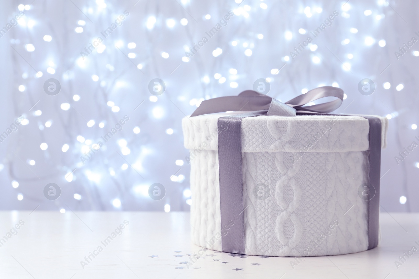 Photo of Christmas gift on table against blurred background