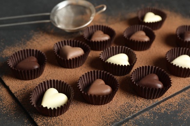 Photo of Beautiful heart shaped chocolate candies on black table