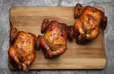 Photo of Delicious grilled whole chickens on grey table, top view