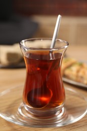 Traditional Turkish tea in glass on wooden table, closeup