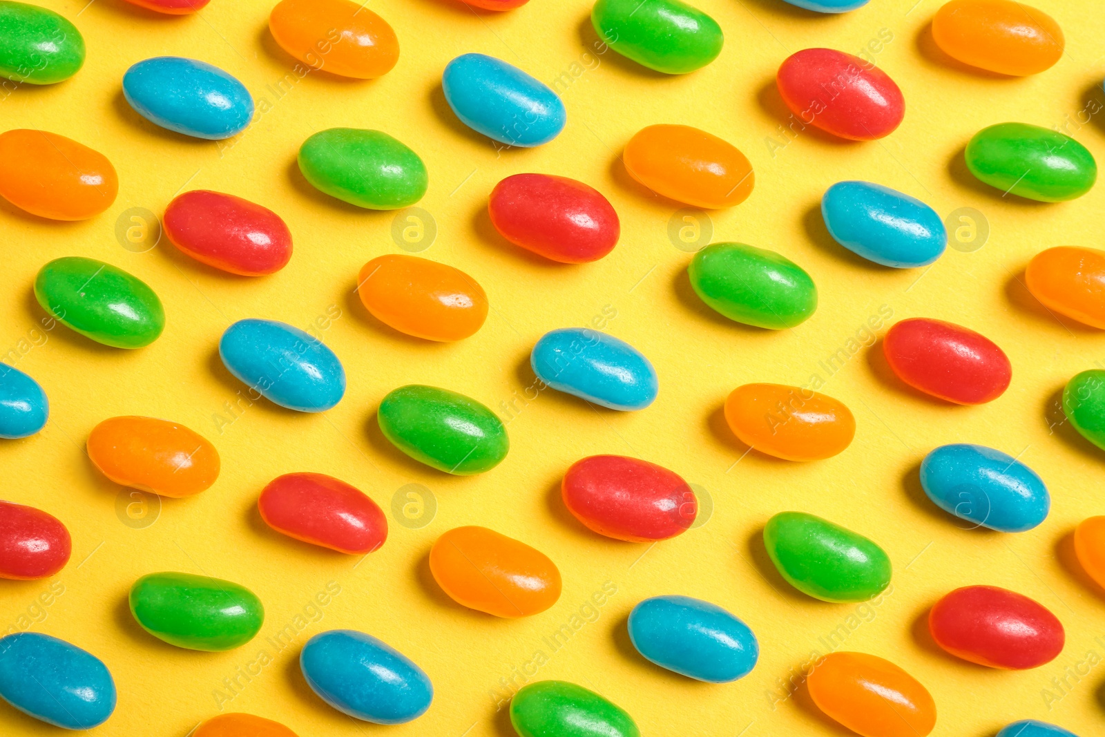 Photo of Flat lay composition with delicious jelly beans on color background