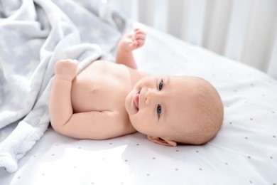 Photo of Cute little baby lying in crib at home