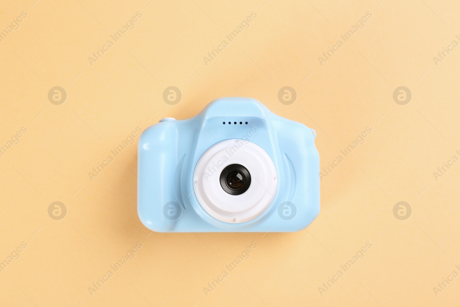 Photo of Light blue toy camera on beige background, top view