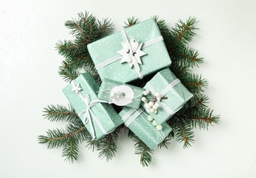 Christmas gift boxes with fir branches on white background, flat lay