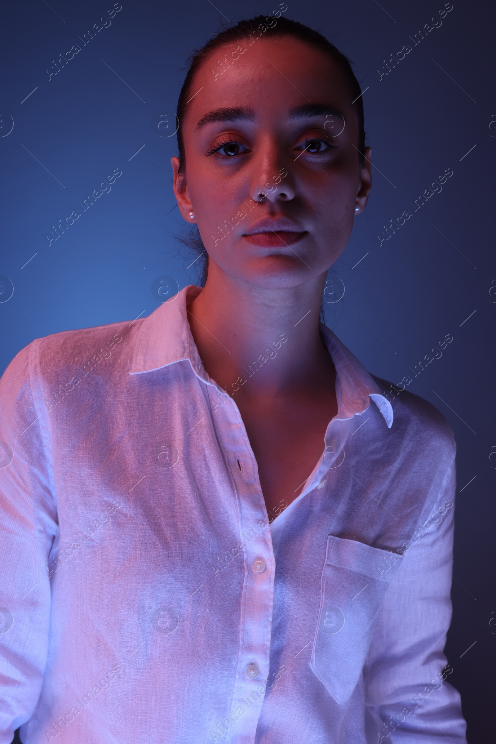 Photo of Portrait of beautiful young woman on blue background with neon lights