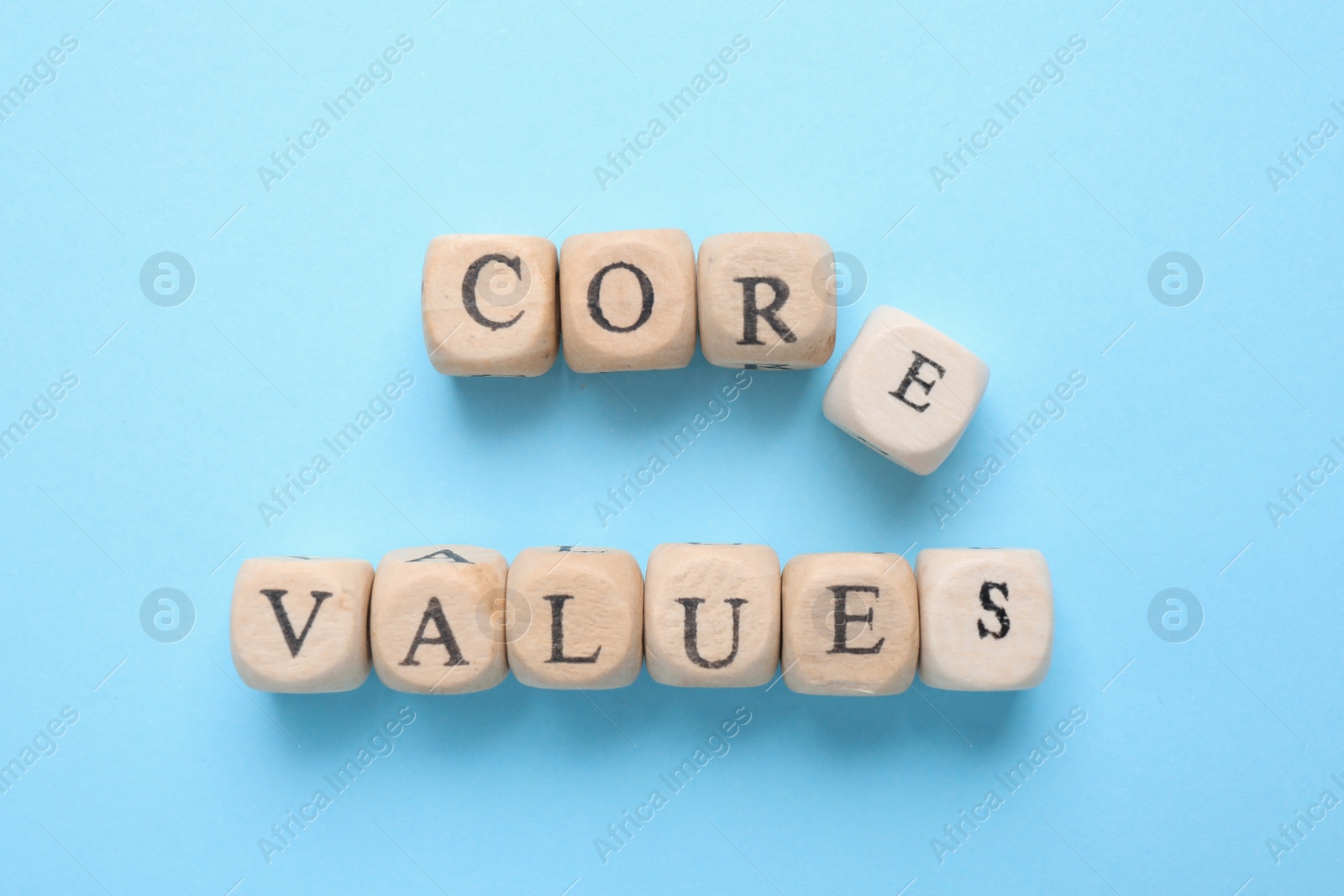 Photo of Beads with phrase CORE VALUES on light blue background, flat lay