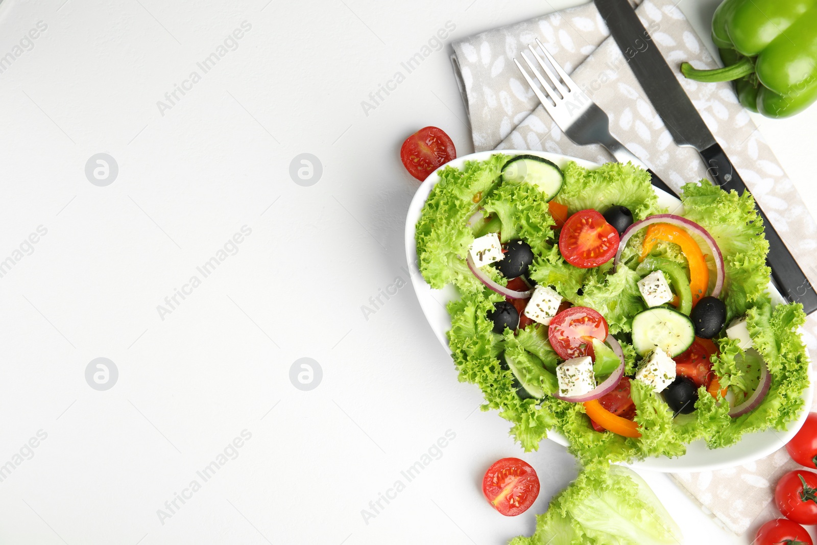 Photo of Tasty fresh Greek salad on white table, flat lay. Space for text