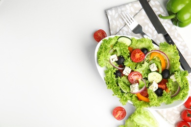 Photo of Tasty fresh Greek salad on white table, flat lay. Space for text