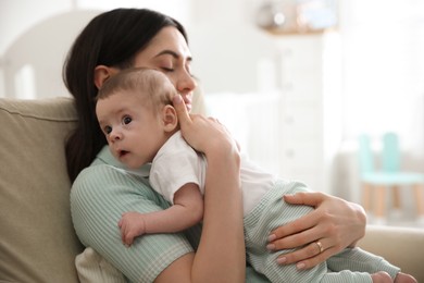 Photo of Young woman with her cute baby at home