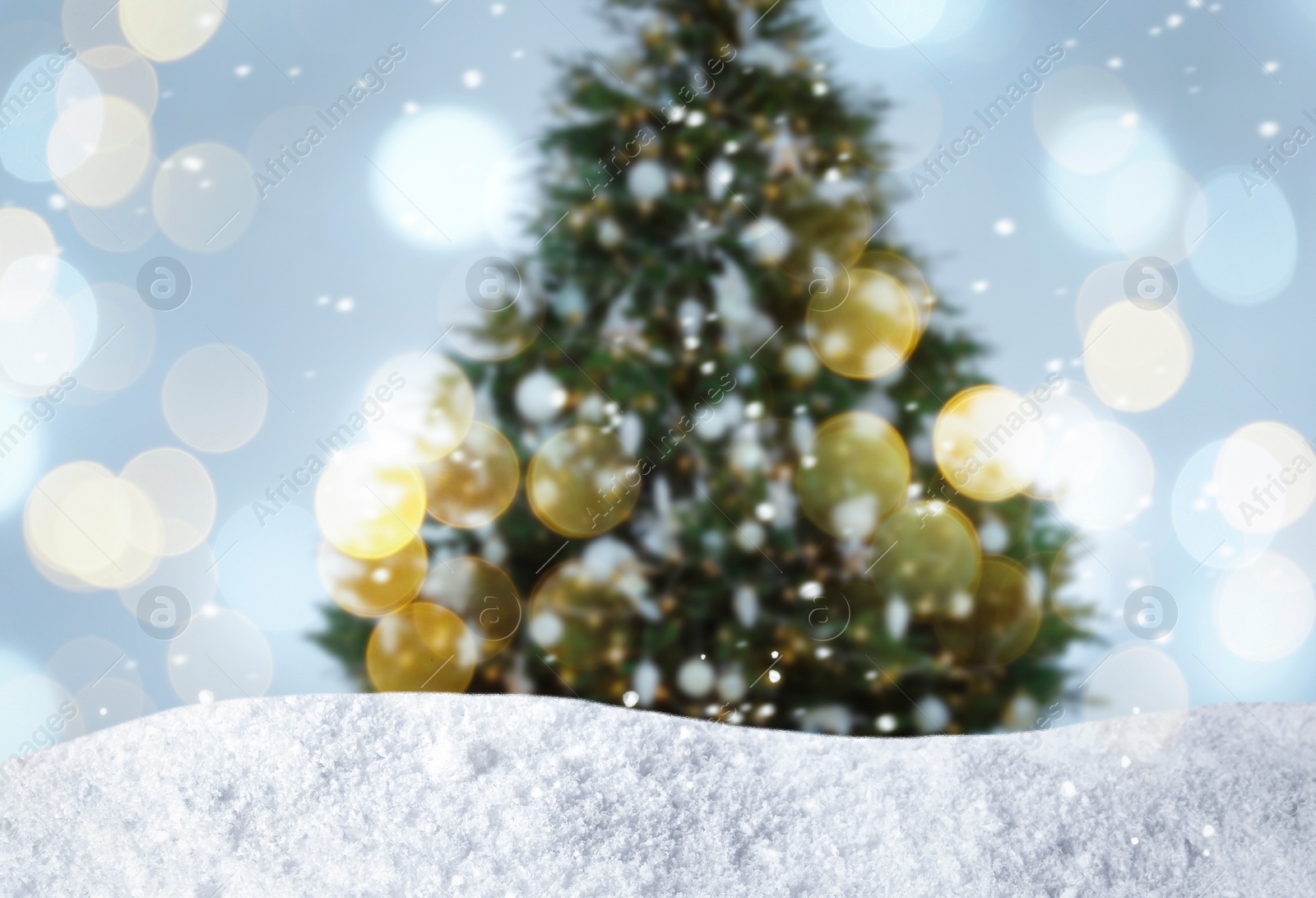 Image of Beautifully decorated Christmas tree and snow on light background. Bokeh effect