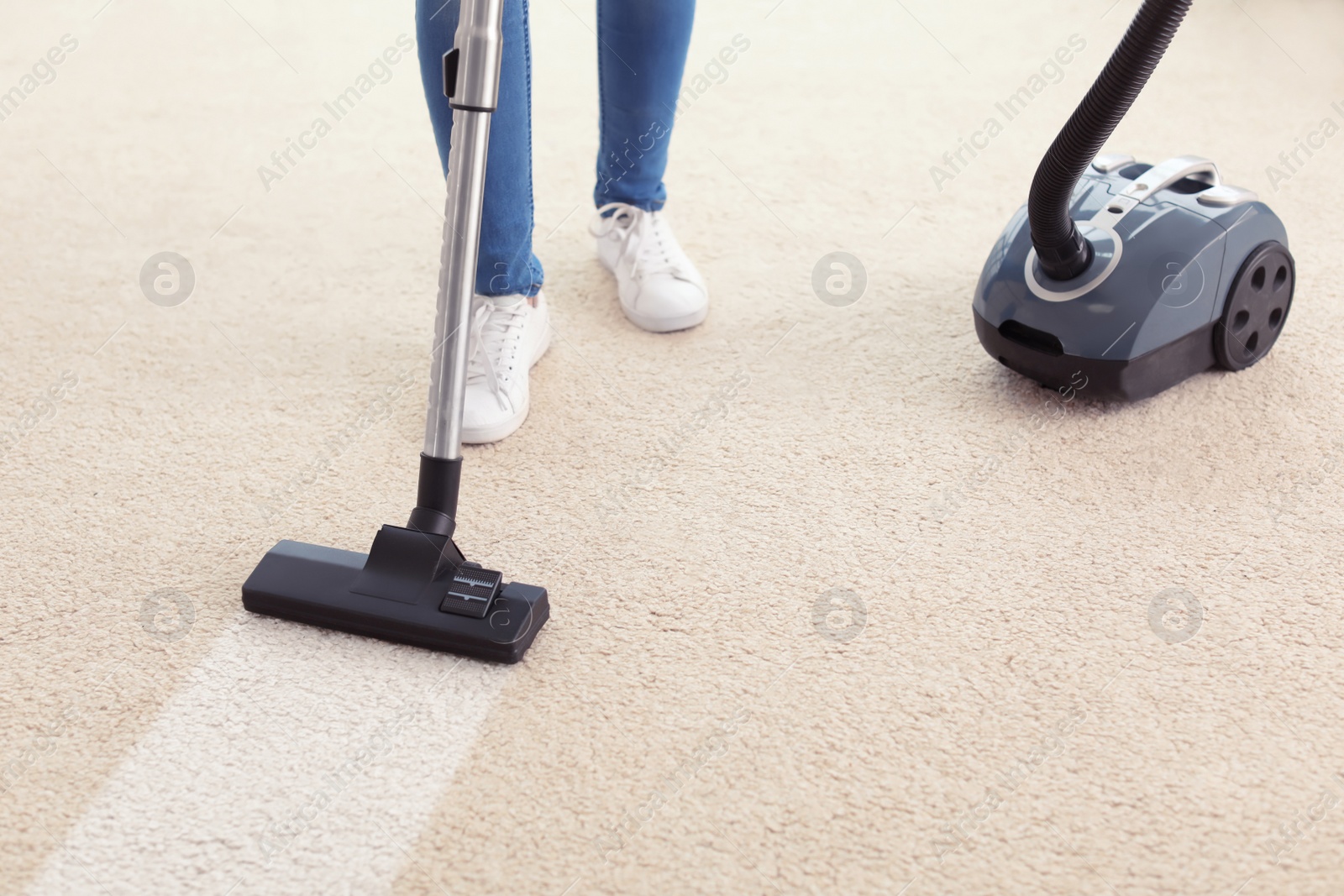 Photo of Woman hoovering carpet at home