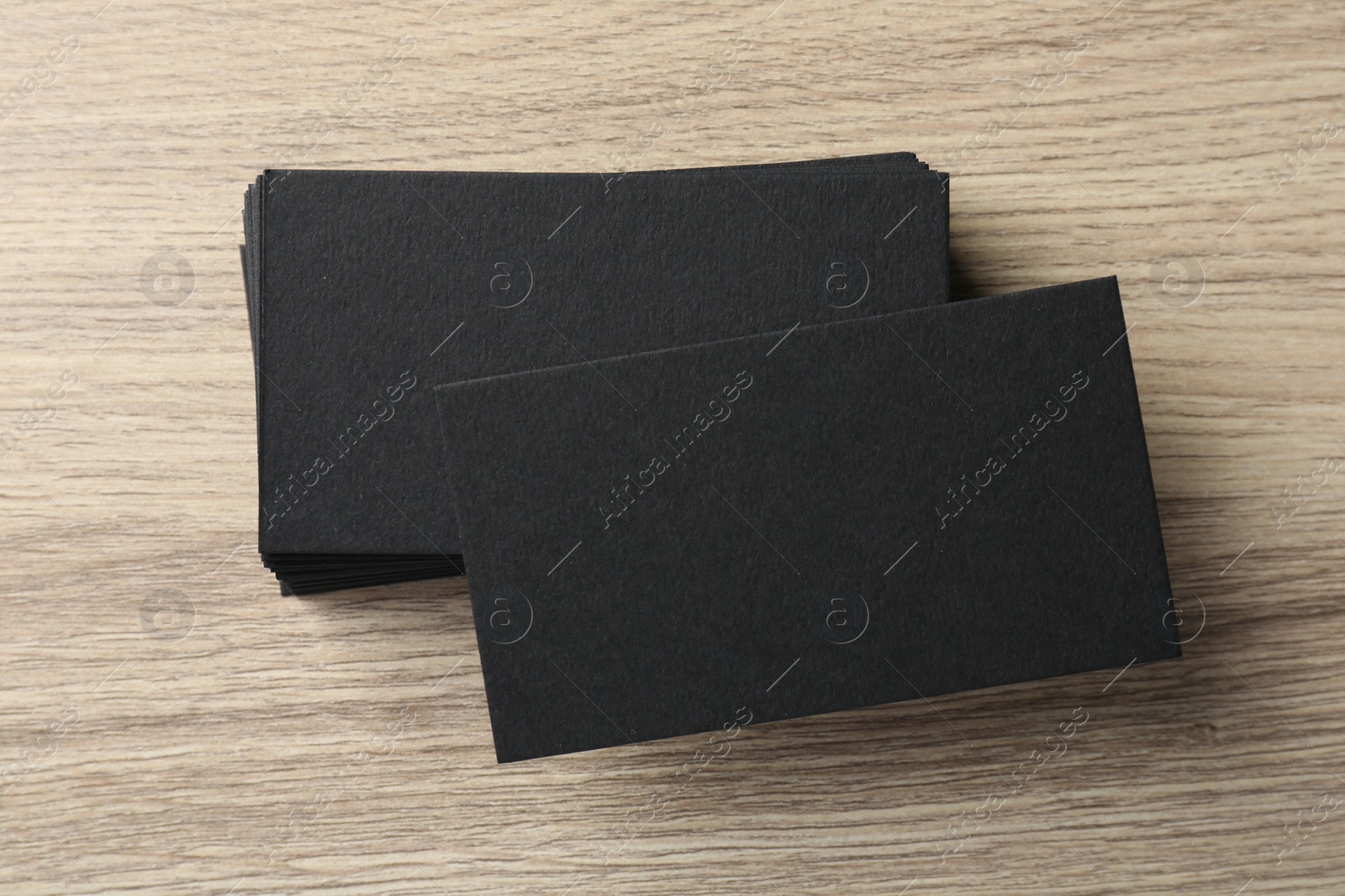 Photo of Blank black business cards on wooden table, top view. Mockup for design