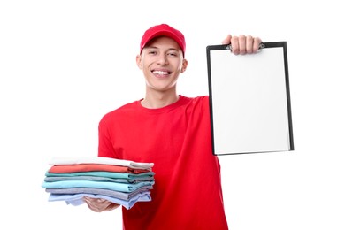 Dry-cleaning delivery. Happy courier holding folded clothes and clipboard on white background